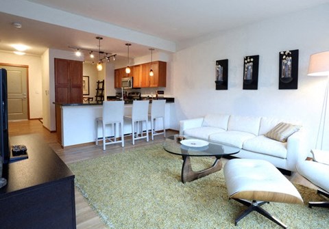a living room and kitchen with a couch and a table